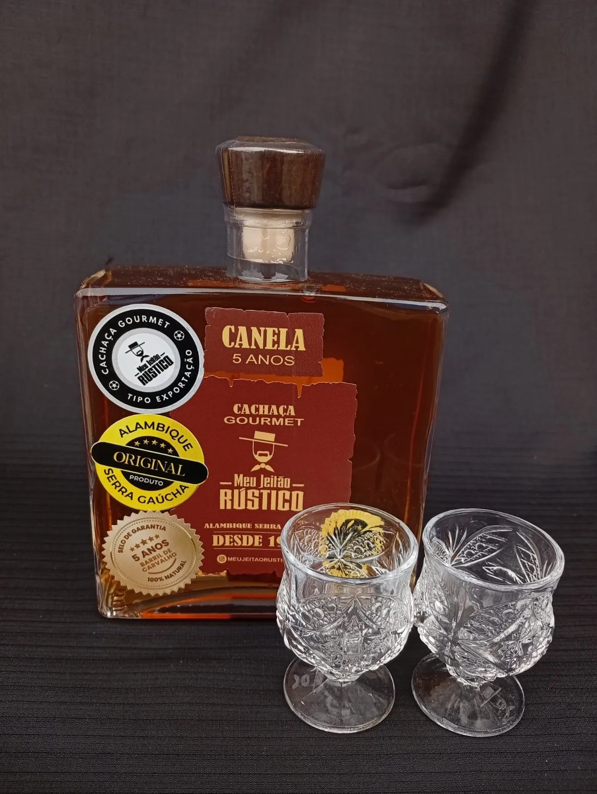 Kit com garrafa de cachaça premium sabor canela de 750 ml e dois copos de vidro
