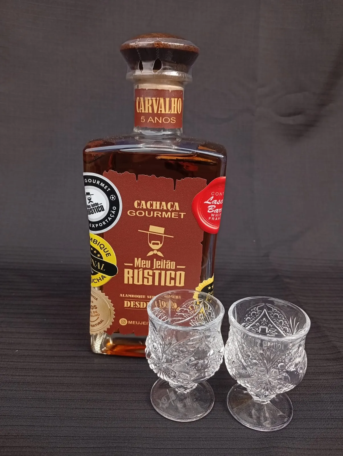 Kit com garrafa de cachaça premium sabor carvalho de 750 ml e dois copos de vidro