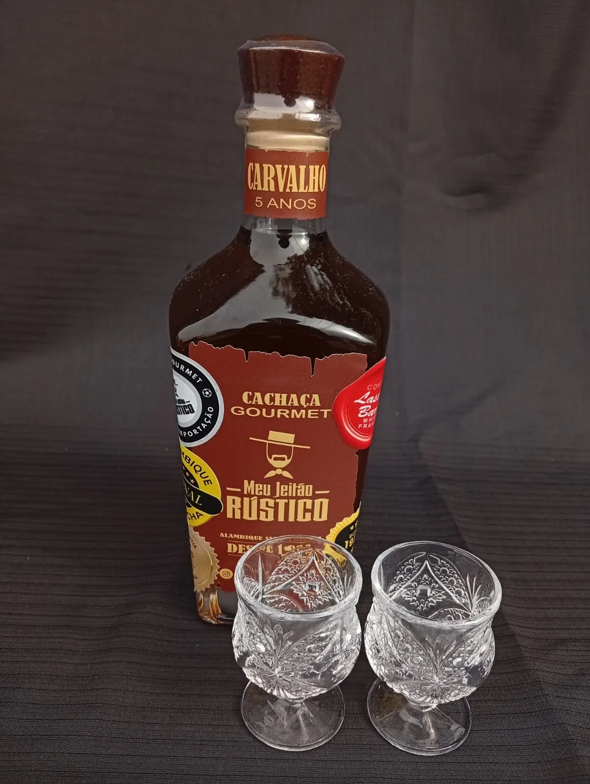 Kit com garrafa de cachaça premium sabor carvalho de 750 ml e dois copos de vidro