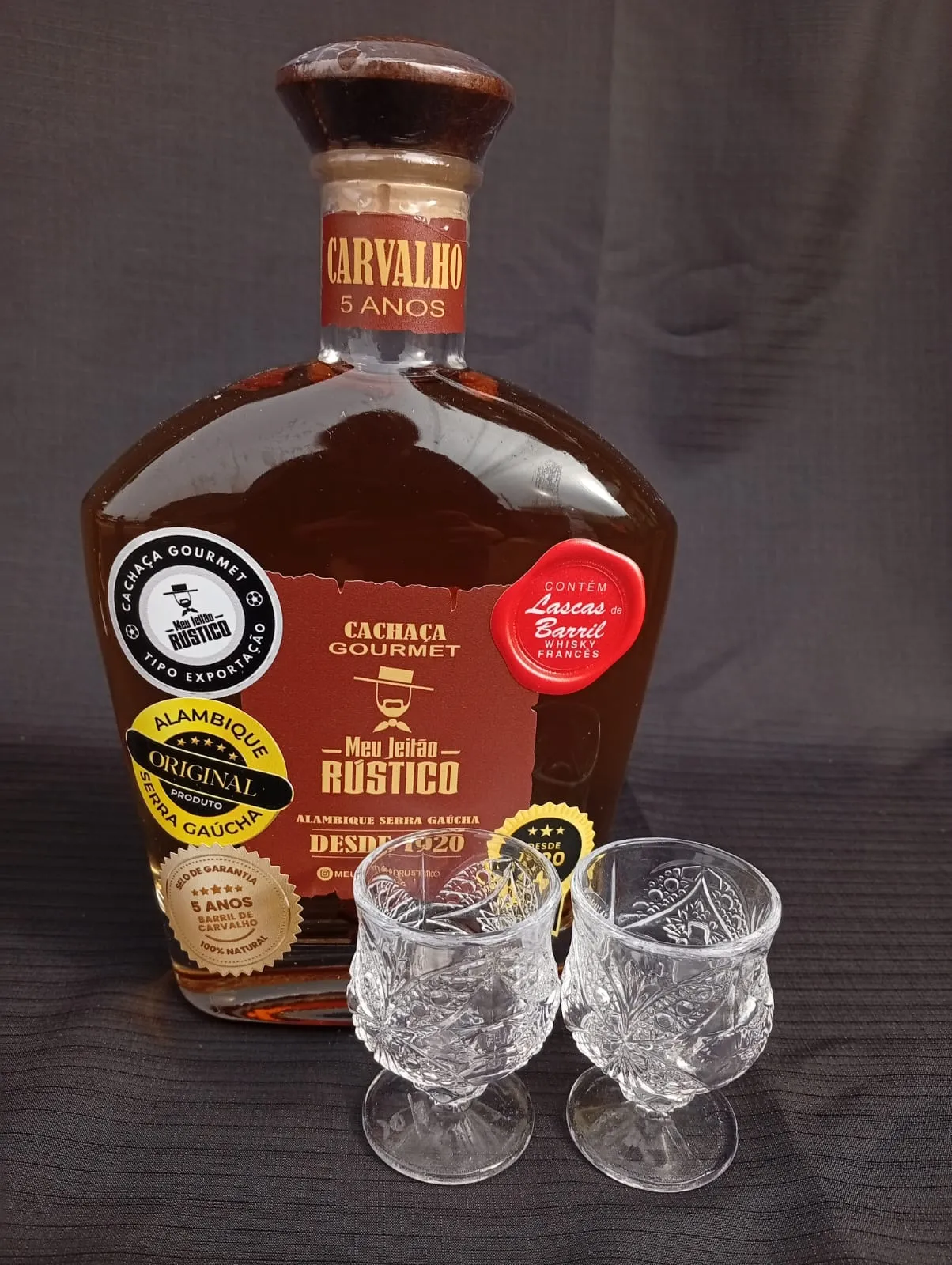 Kit com garrafa de cachaça premium sabor carvalho de 750 ml e dois copos de vidro