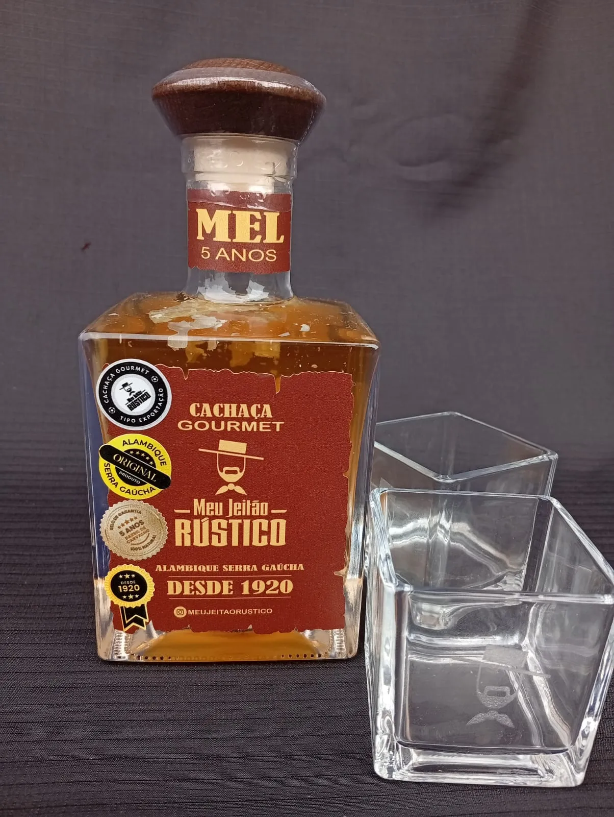Kit com garrafa de cachaça premium sabor mel de 500 ml e dois copos de vidro