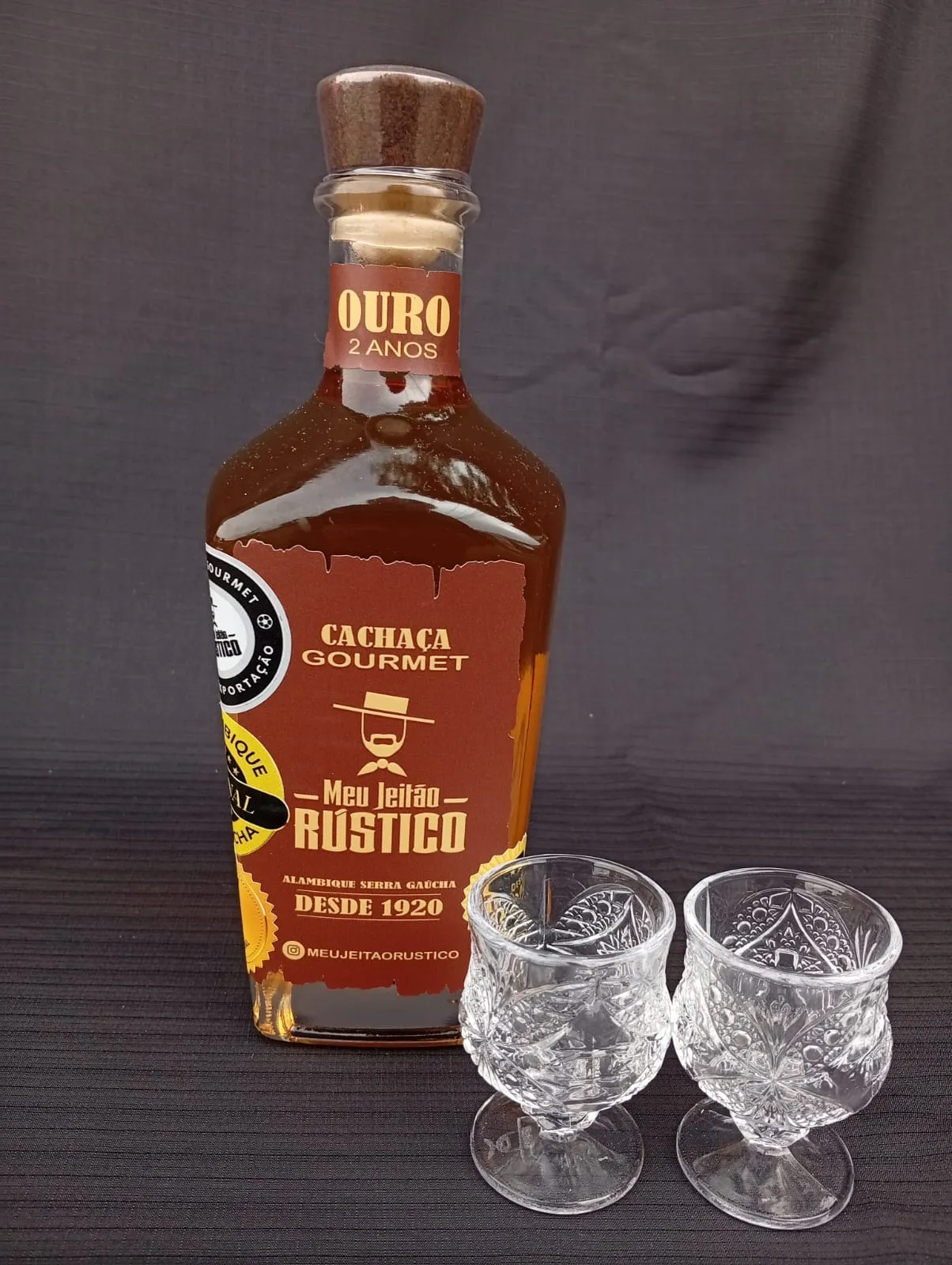 Kit com garrafa de cachaça premium sabor ouro de 750 ml e dois copos de vidro