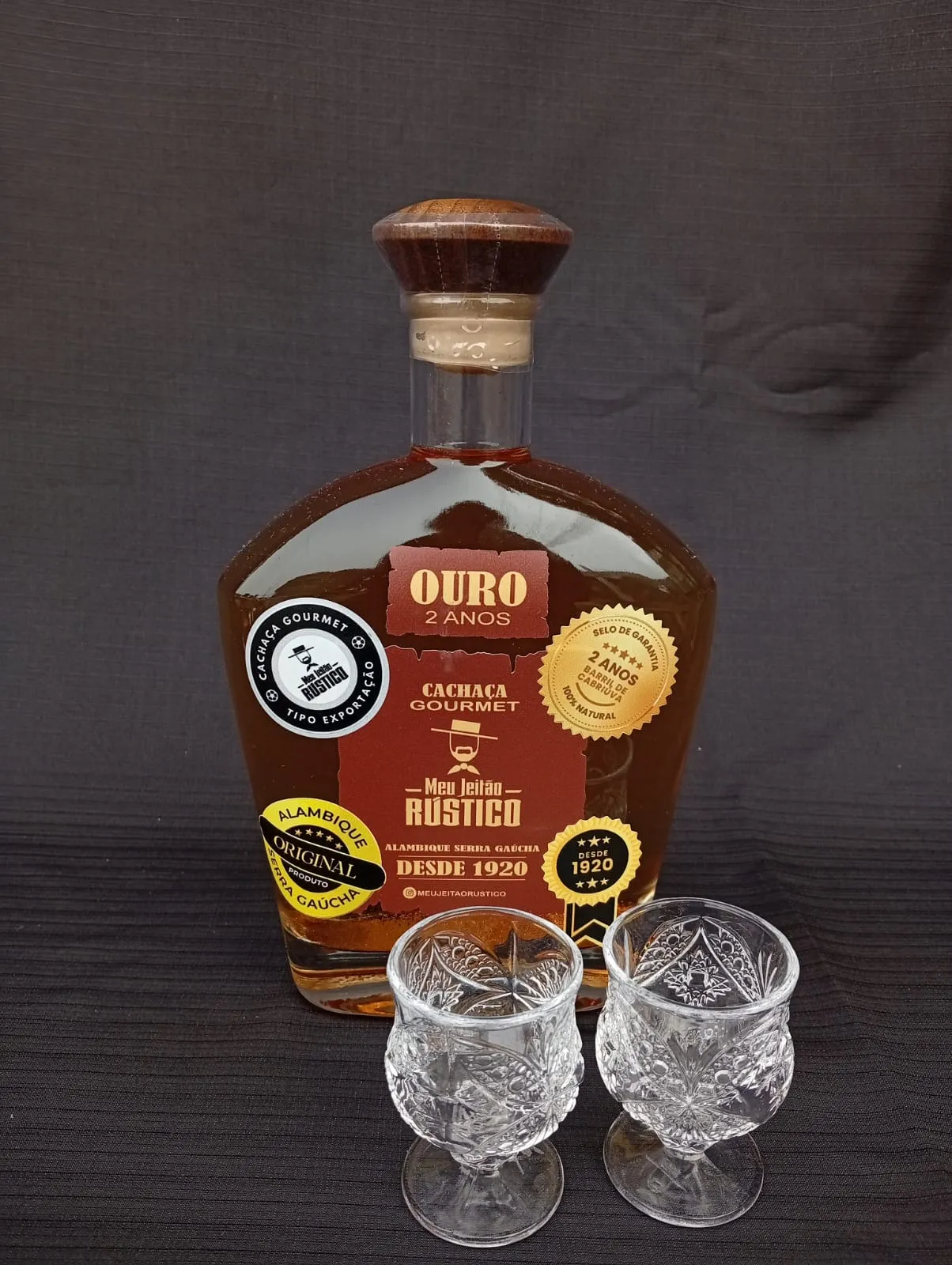 Kit com garrafa de cachaça premium sabor ouro de 750 ml e dois copos de vidro